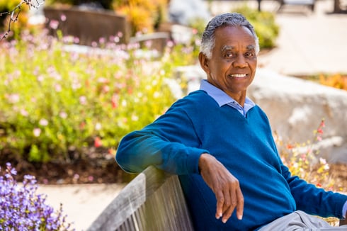 man smiling on bench